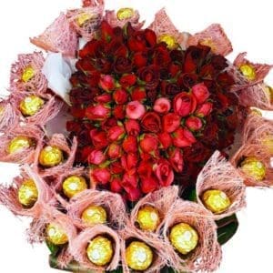 A basket of Red Roses in the shape of a heart surrounded by Chocolates, close up